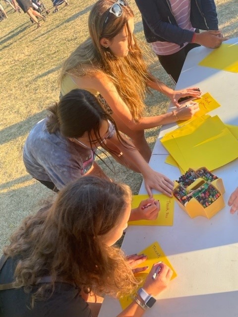 a young girl writing on a card
