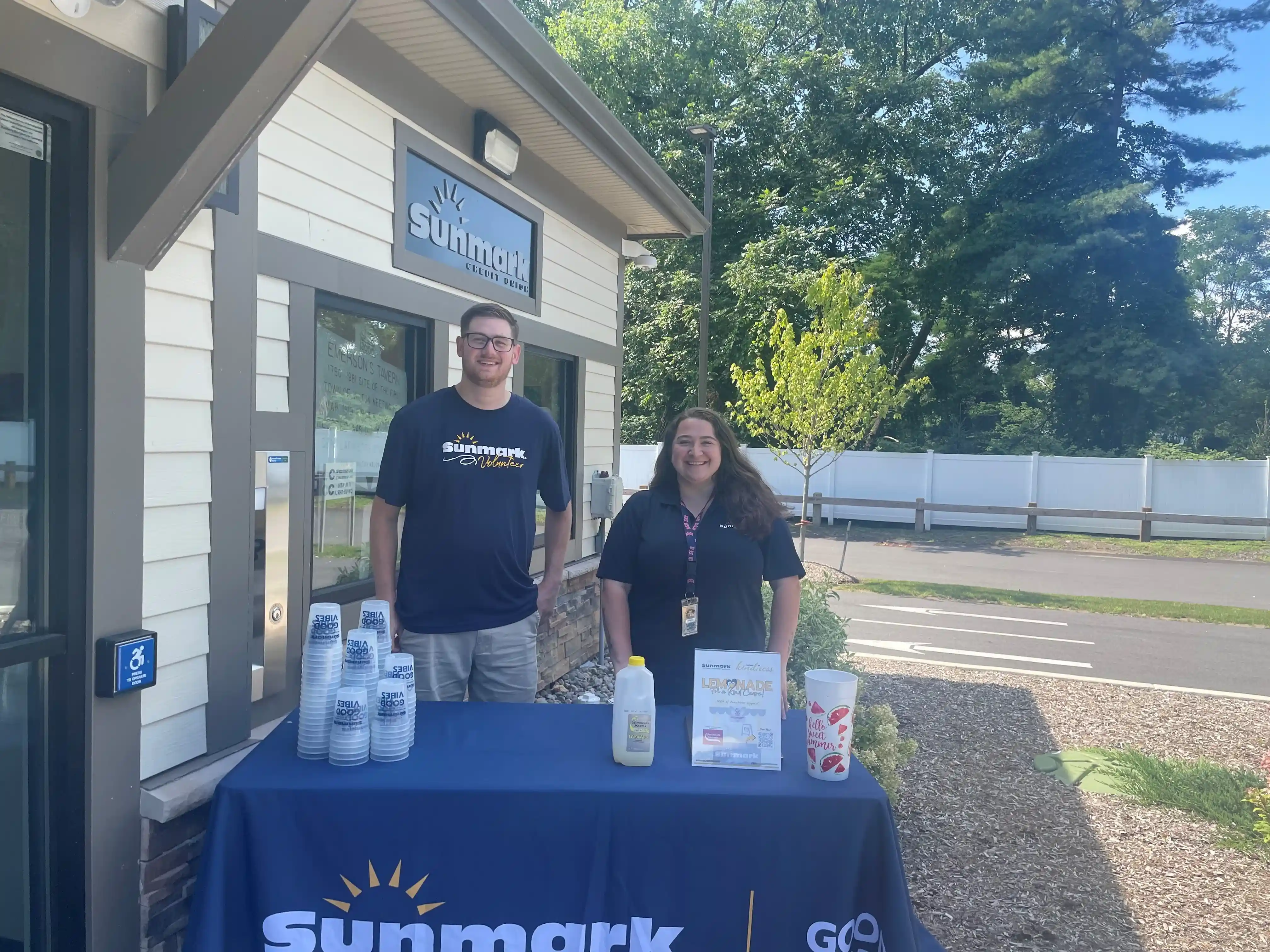 Volunteers standing behind a Sunmark booth