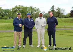 A team posing for a picture on the green