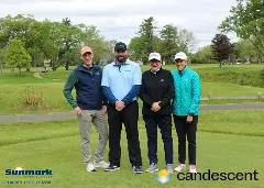 A team posing for a picture on the green